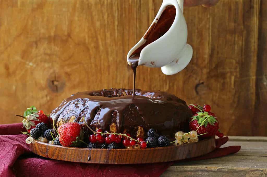 putting chocolate ganache on a cake