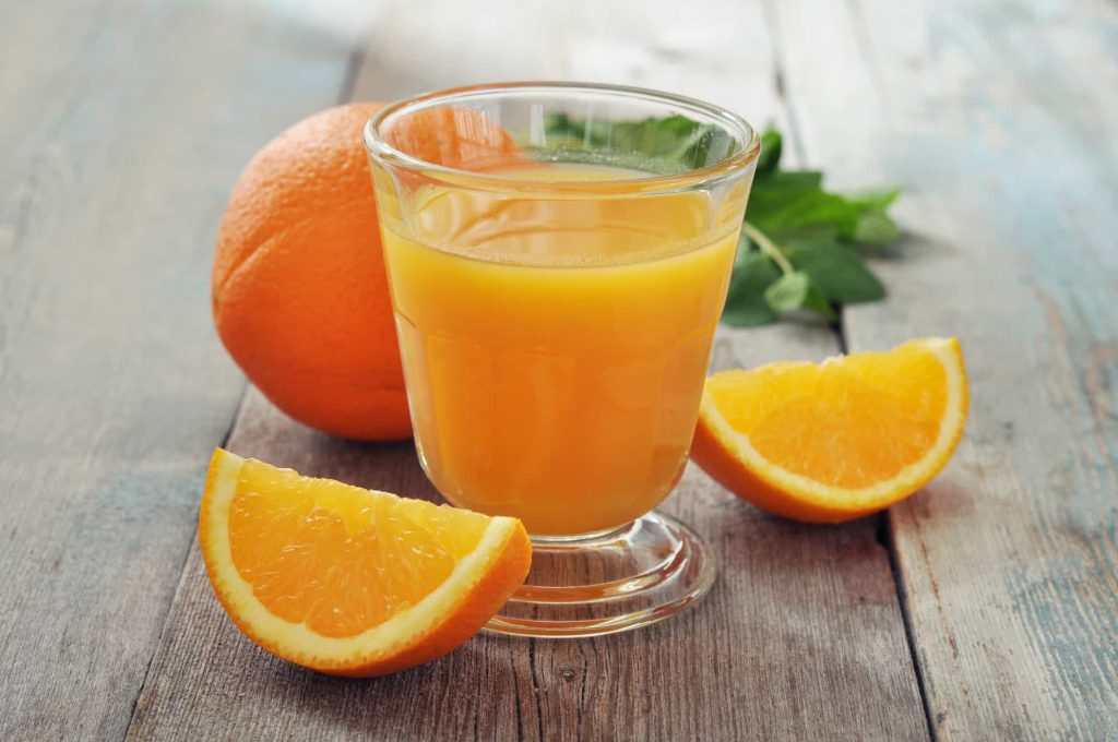 orange juice in glass and fresh orange fruits