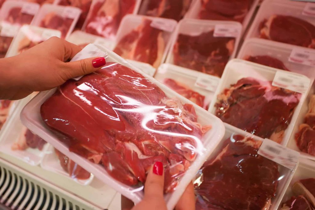 woman holding packed meat with potassium lactate in the supermarket