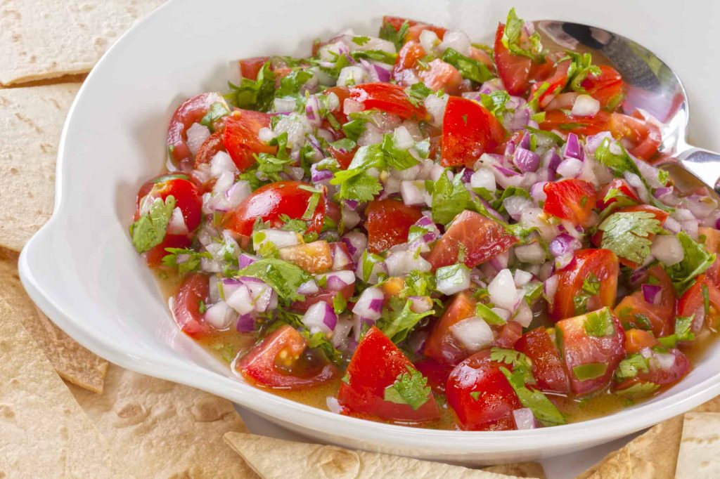 Pico de gallo, or salsa fresca, is a fresh, uncooked relish in Mexican cuisine, made from tomatoes, red onion, chilli, olive oil, lime juice and coriander.
