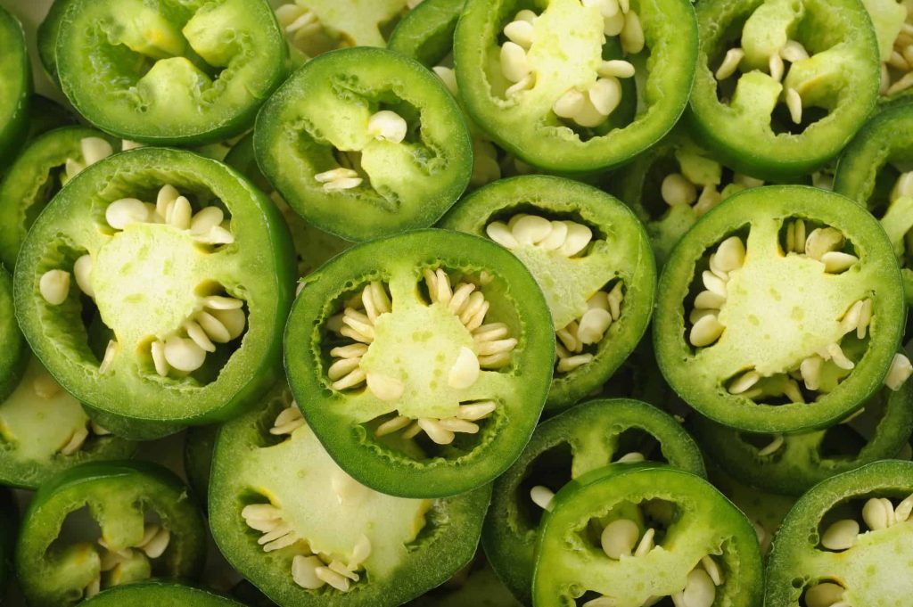 sliced green jalapenos with white seeds