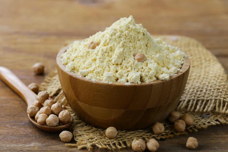 chickpea flour in a bowl and chickpeas on a table